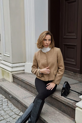 a lady wears a camel wool jacket with black skinny jeans